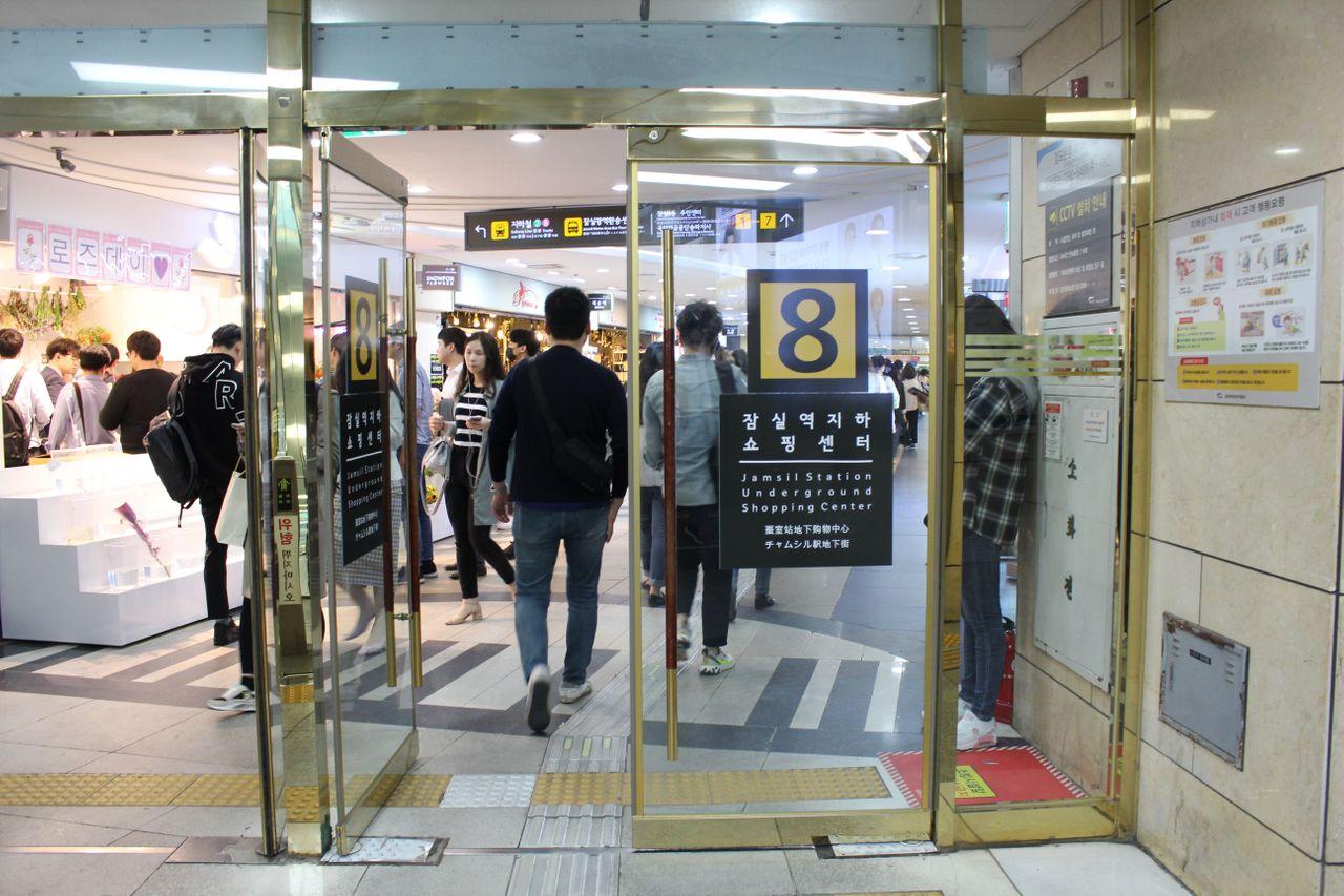 蚕室地下购物中心入口，顾客正排队进入，适合购物和休闲。