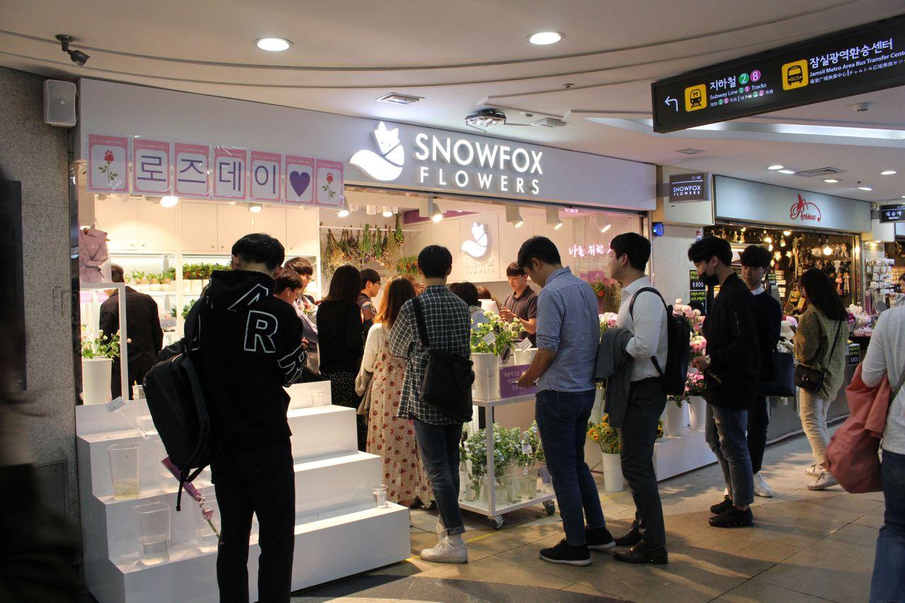 蚕室地下购物中心内部，有一家名为Snowfox Flowers的花店，吸引顾客。