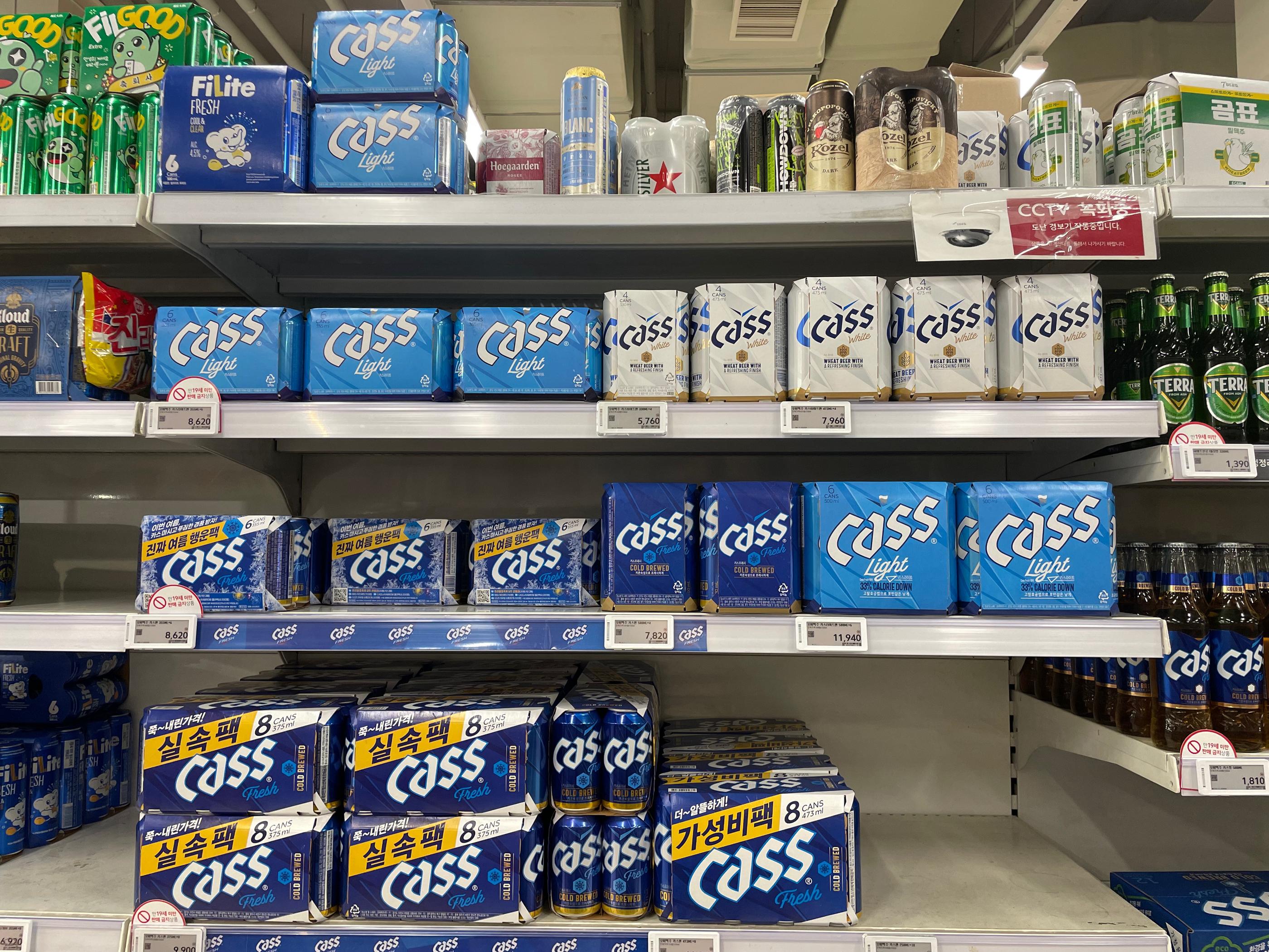 Homeplusのビール売り場に並んでいるcassビールの缶が積まれている様子。