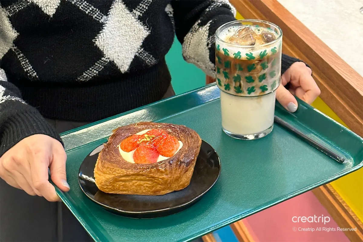 Close-up of COLECTIVO's signature oat latte and pastry pie, highlighting the rich flavor and artisanal craft of this coffee and pastry pairing.