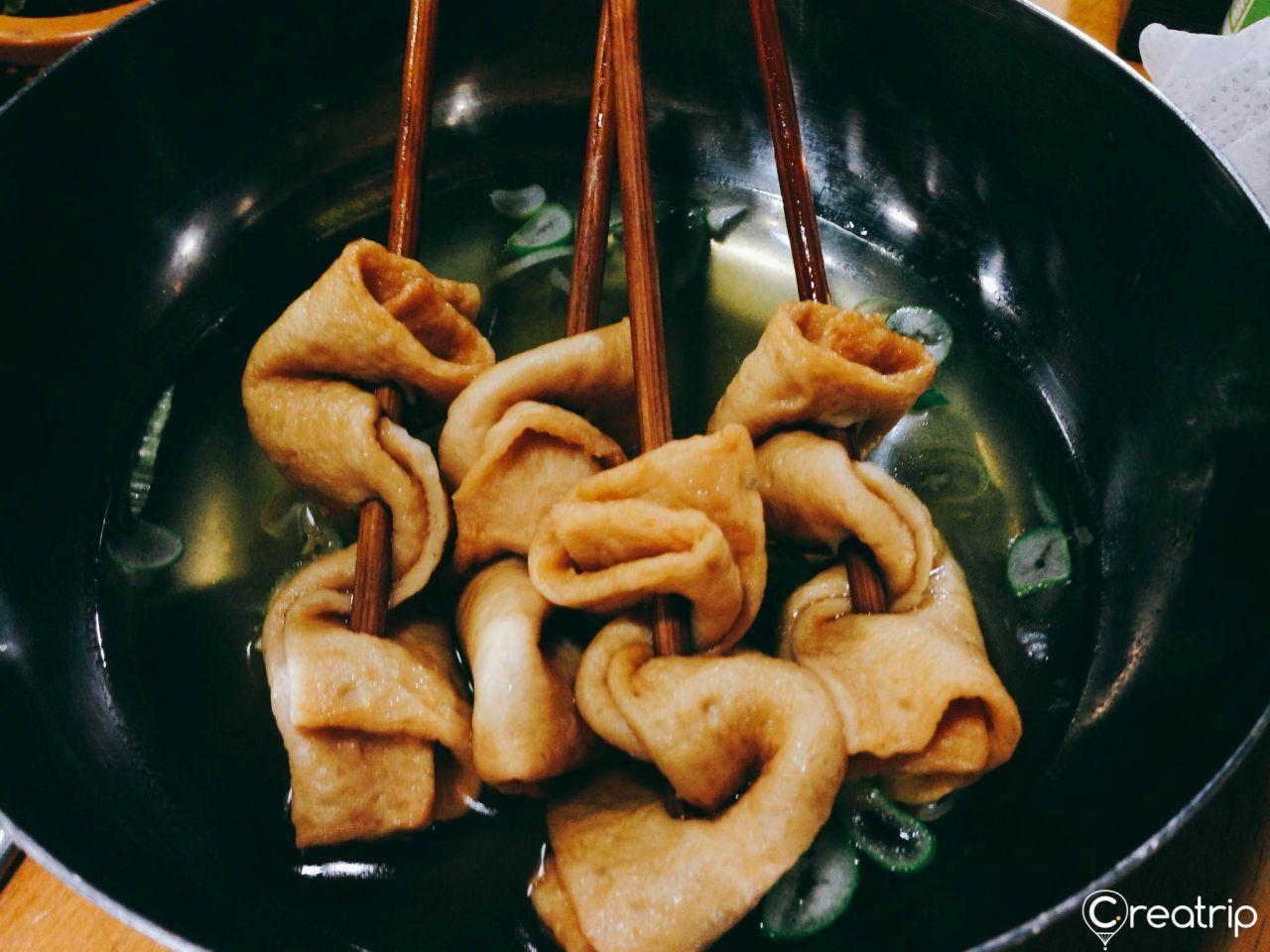 Plate of assorted Korean side dishes including kimchi, garlic, and sauces served at Jokbal restaurant.