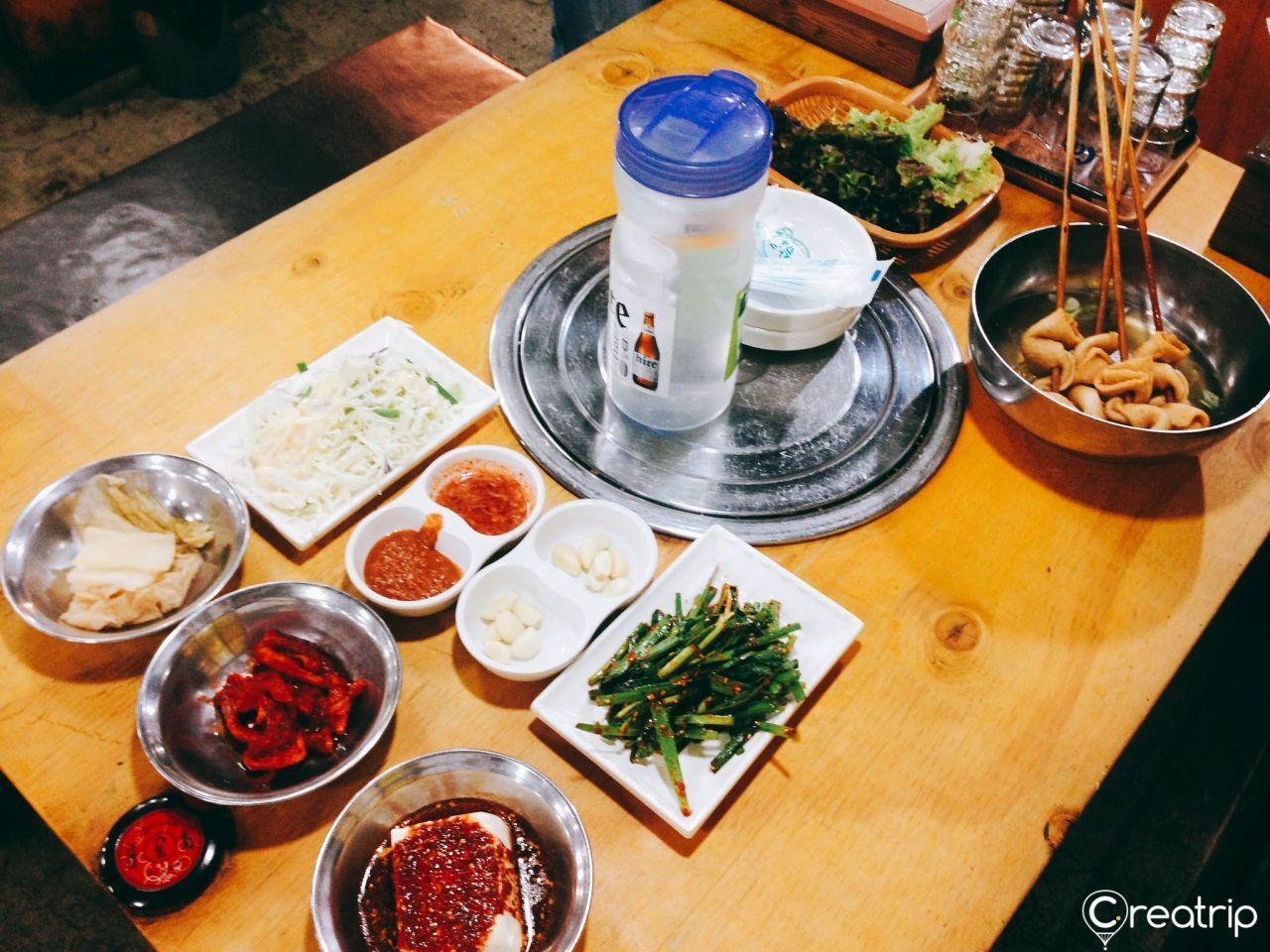 A table full of Korean side dishes ready to complement the main pork dish at Jokbal restaurant.
