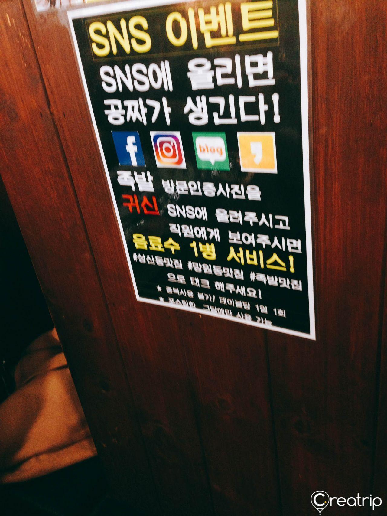 SNS promotional poster at Jokbal restaurant offering free drinks for social media check-ins with hashtags.