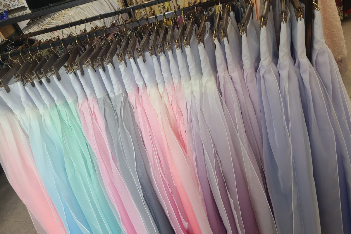 多樣顏色和款式的韓服整齊懸掛在衣架上,提供給顧客豐富的選擇和穿搭靈感.