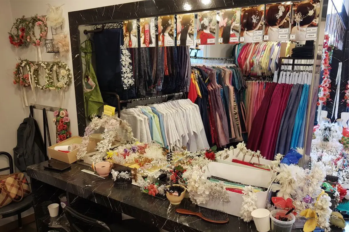Inside Ohnelharu Hanbok shop, a vanity table is decorated with flower crowns and hair accessories for customers to use.