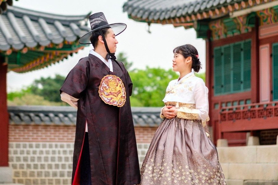 Visitors in stylish hanbok captured amidst the picturesque setting of Gyeongbokgung Palace.
