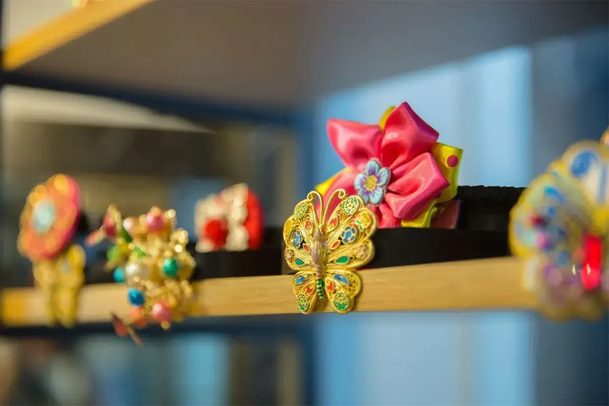 A showcase of traditional Korean hair clips at Ohnelharu Hanbok shop, including a butterfly design and floral decorations.