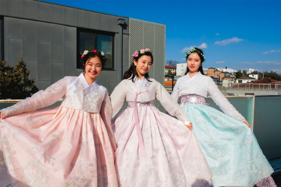 Hanbok tourists strolling through Gyeongbokgung, harmonizing with the historic setting.