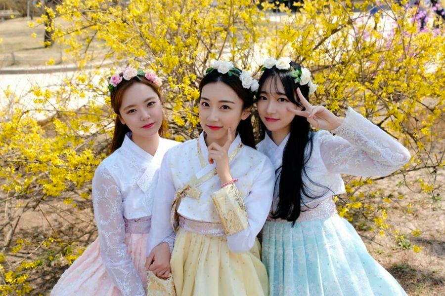 Traditional hanbok clad visitors engaging with the serene Gyeongbokgung environment.