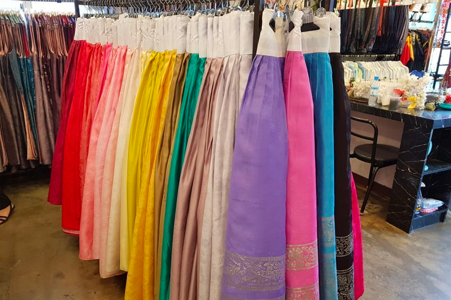 Hanbok-clad visitors exploring the scenic beauty of Gyeongbokgung Palace grounds.