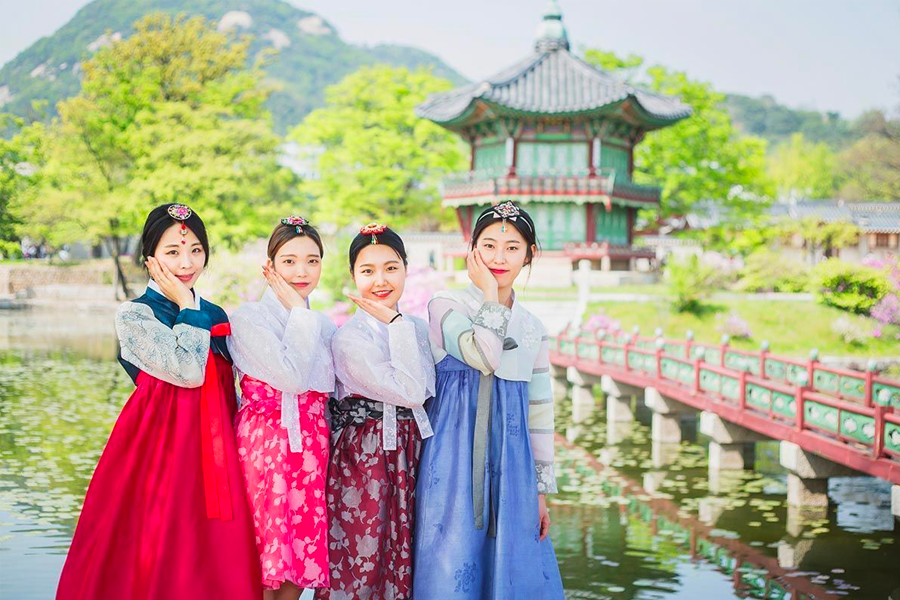 Tourists dressed in hanbok exploring the historic and cultural site of Gyeongbokgung Palace.