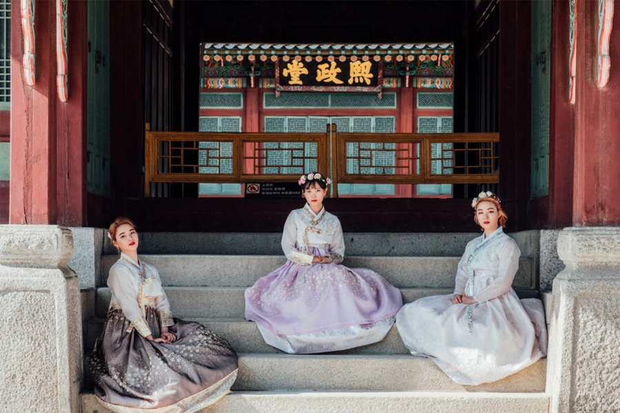 A rack full of colorful hanboks, showcasing a wide range of options for rental.