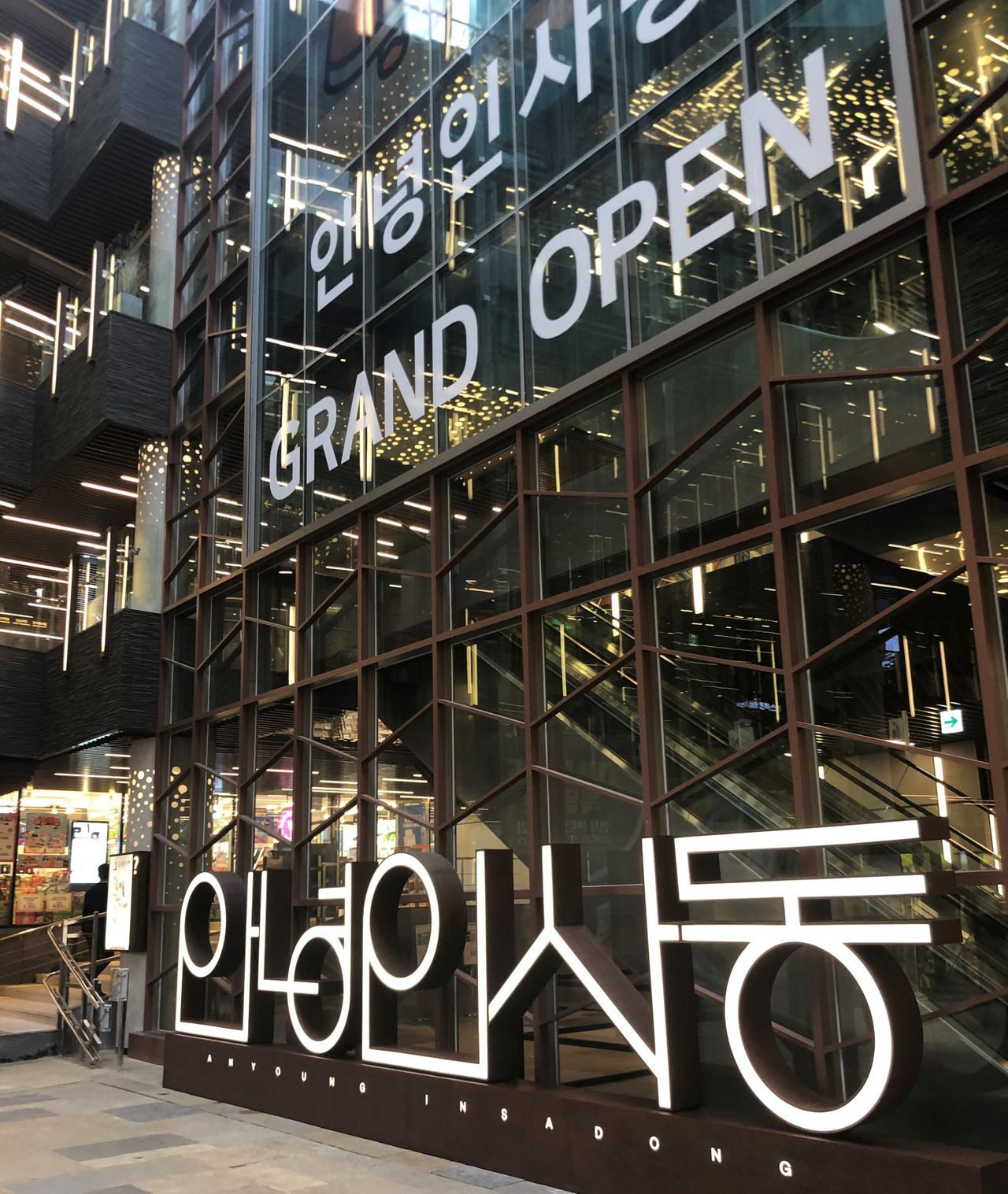 서울 인사동에 위치한 현대식 건축물의 외관, 다양한 가게들과 고층 건물이 조화롭게 어우러져 있음.