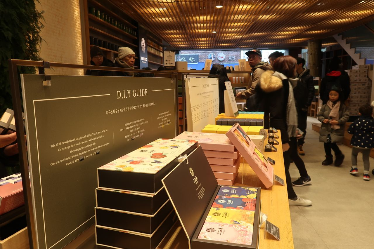 서울 인사동의 오설록 안에 있는 디스플레이, 다양한 차 제품과 매장에서 제공하는 DIY 서비스 안내판이 보임.