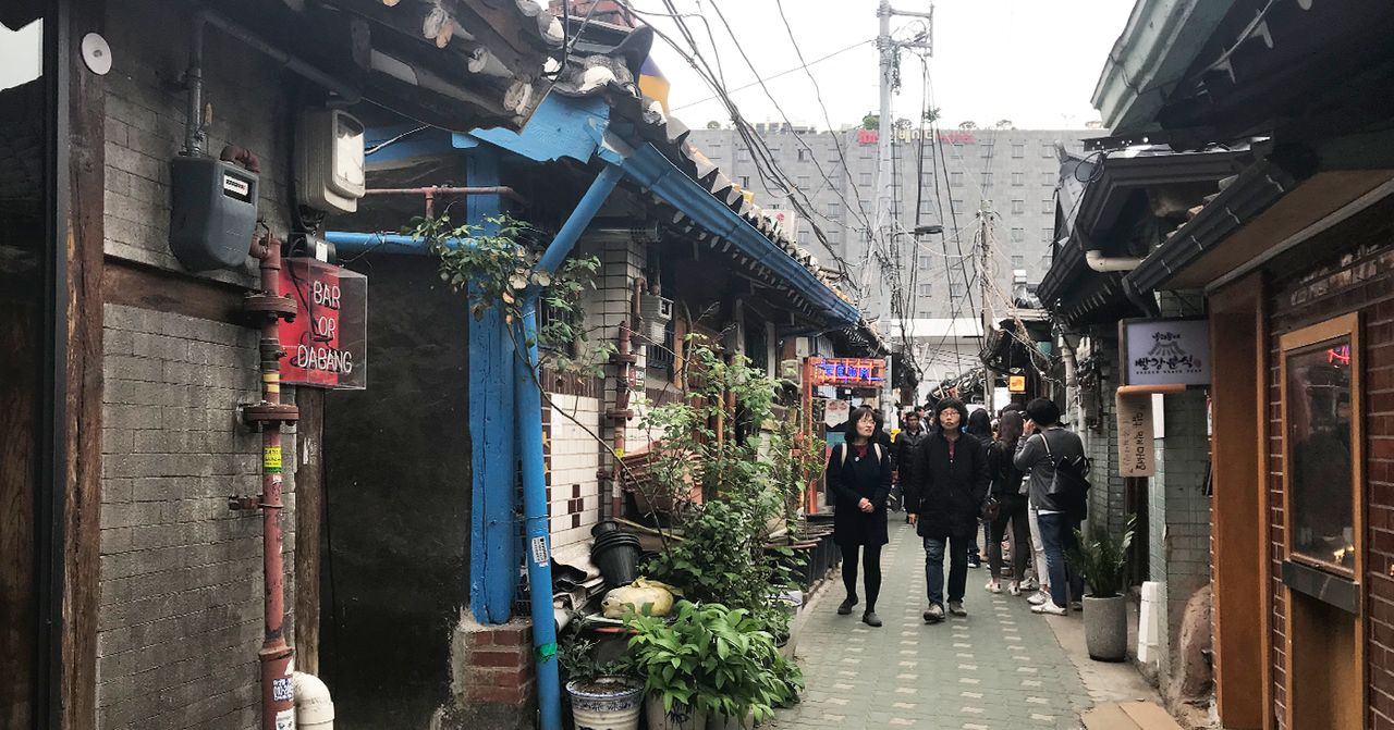 서울의 전통적인 한옥 건물들 사이를 걸으며 경험할 수 있는 독특한 거리 풍경.