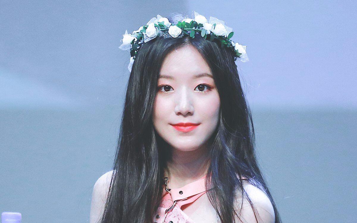 Image showcasing a blurred face wearing a floral crown on stage.