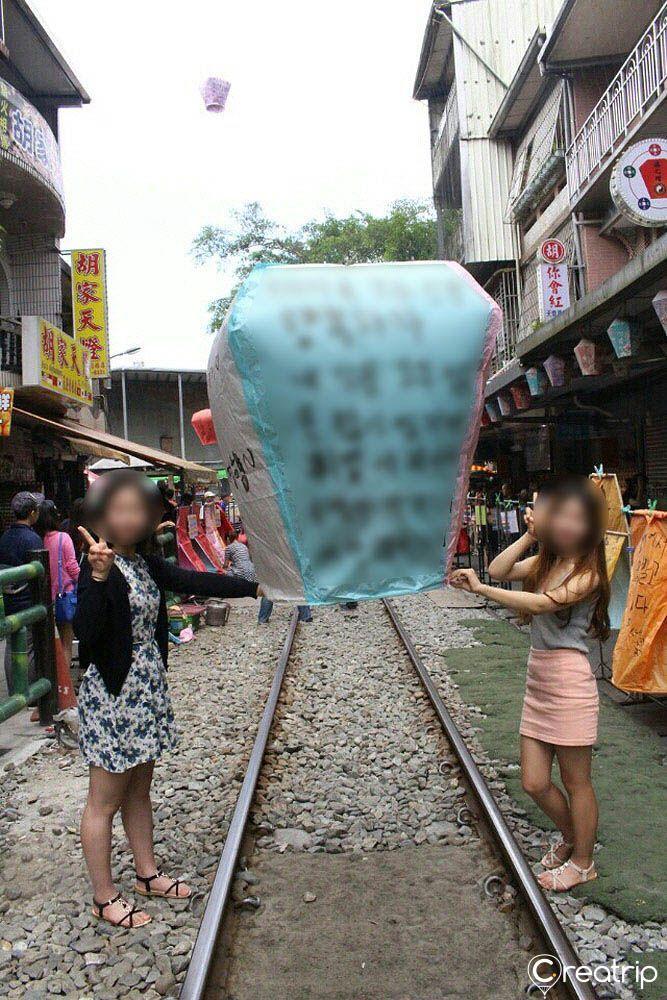Sky lanterns being released on the railway tracks of Pingxi, Taiwan, a traditional activity loved by both locals and tourists.