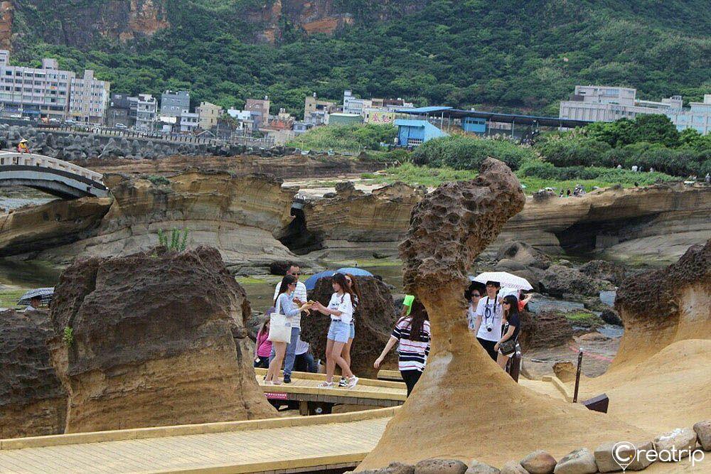 Tourists exploring the iconic Queen's Head rock formation at Yehliu Geopark, a famous sightseeing hotspot in Taiwan.