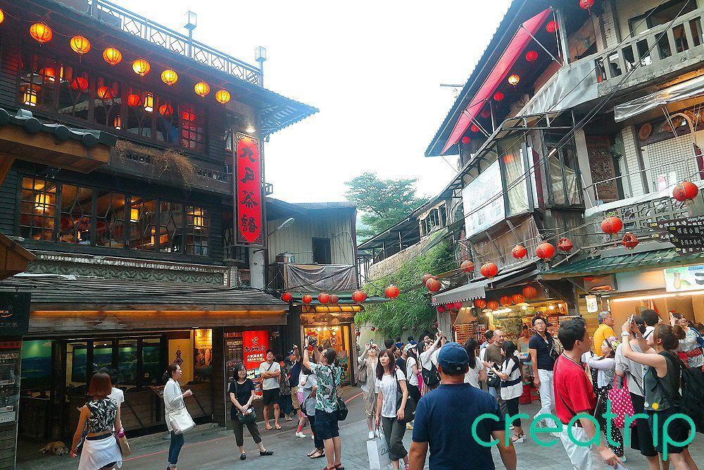 The streets of Jiufen, Taiwan, filled with atmospheric red lanterns and traditional wooden architecture, reminiscent of scenes from Spirited Away.