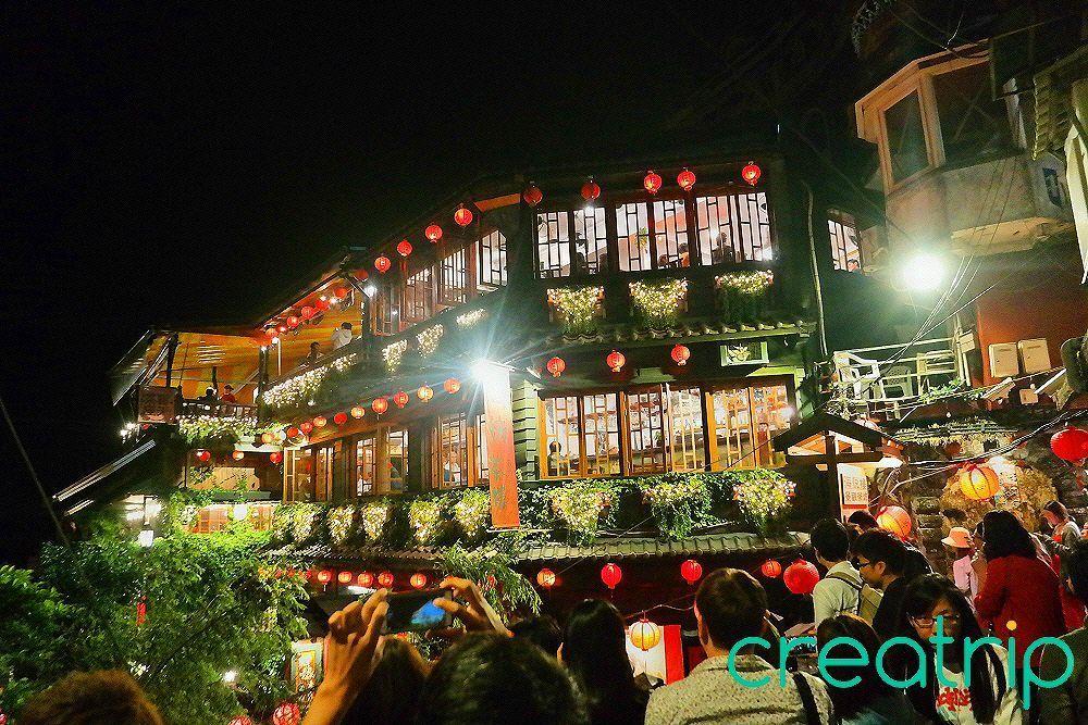 Night view of Jiufen teahouse, glowing with red lanterns, capturing the charming and nostalgic ambiance of the area, popular among tourists.