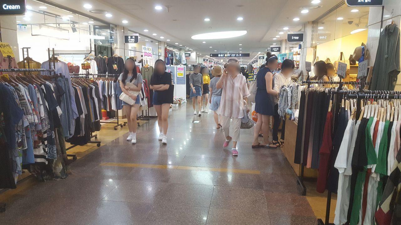 韩国地下街的购物场景，时尚服装店铺林立，提供经济实惠的购物选择。