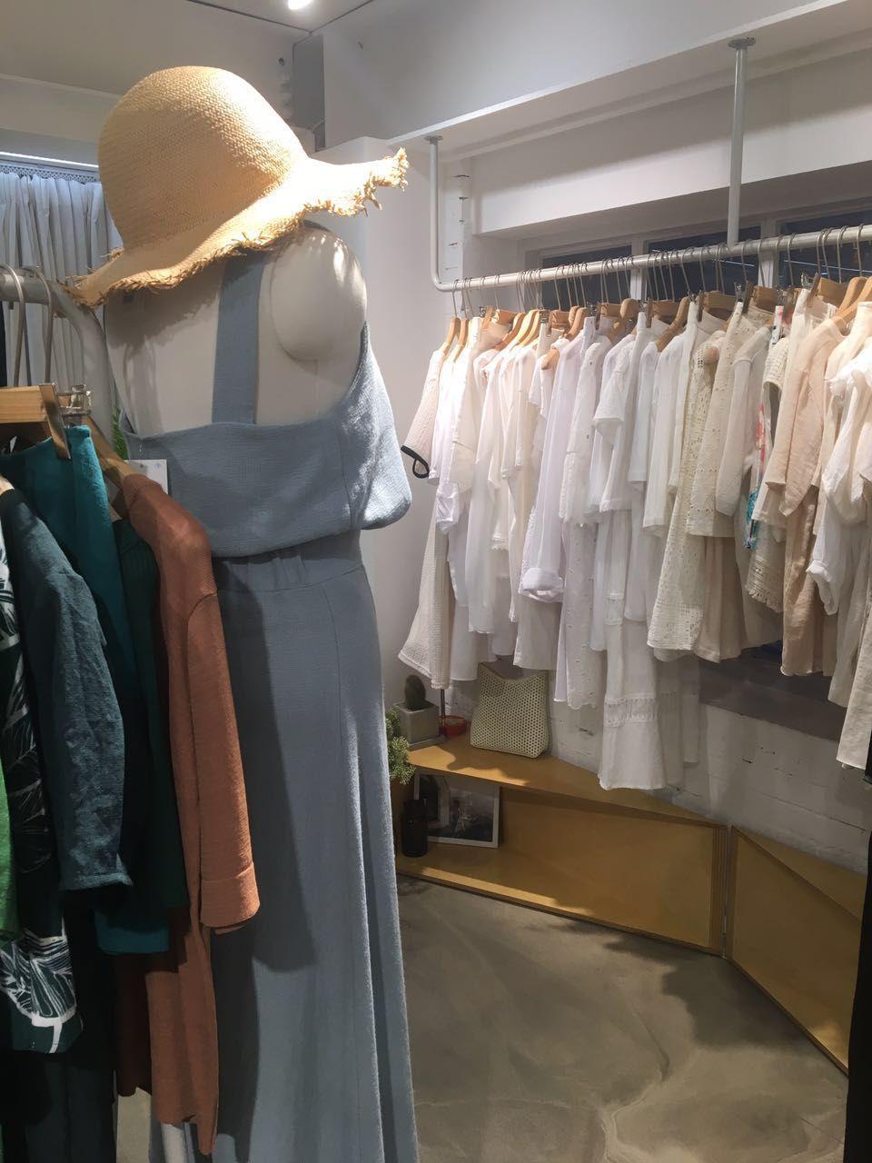 新沙洞林荫道时尚服饰店内景，展示多款清新时尚的韩国服装。