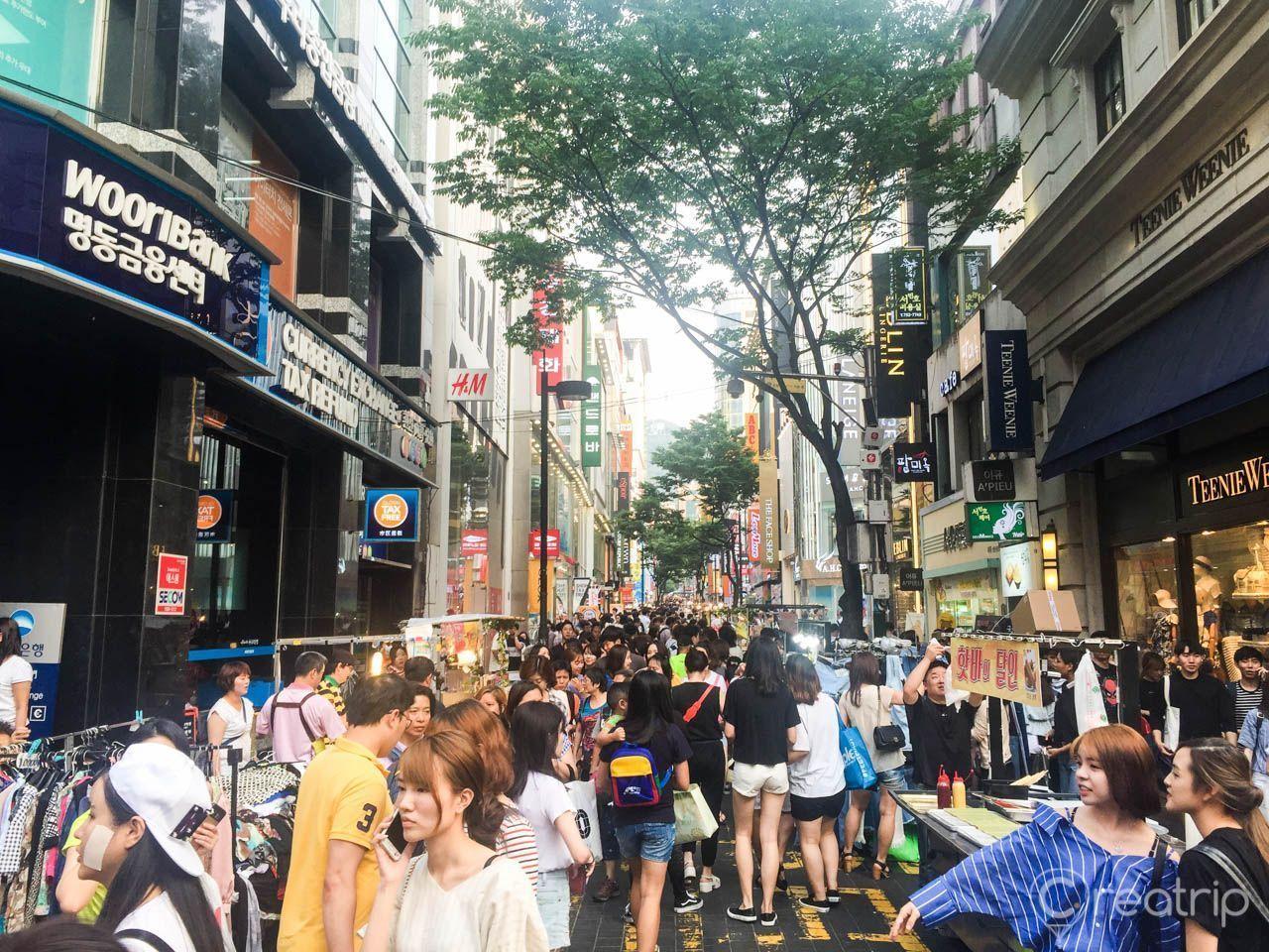 明洞购物街的繁华景象，大量游客汇聚，体验购物与餐饮的多样化。