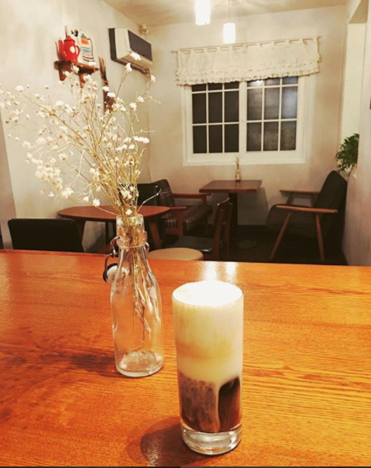 崔家咖啡廳的溫馨角落，桌上放著鮮花和冰咖啡飲品。