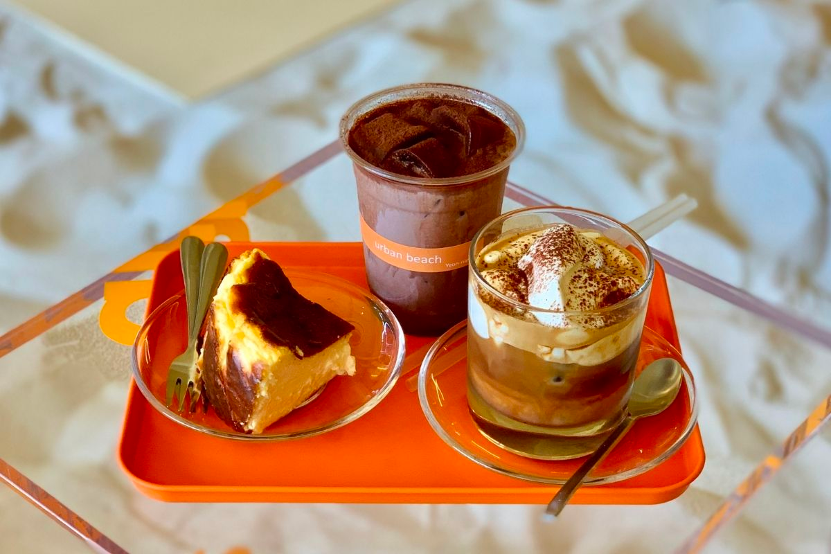 咖啡館桌上的兩杯飲品和一份蛋糕，韓國咖啡文化體驗的絕佳選擇。