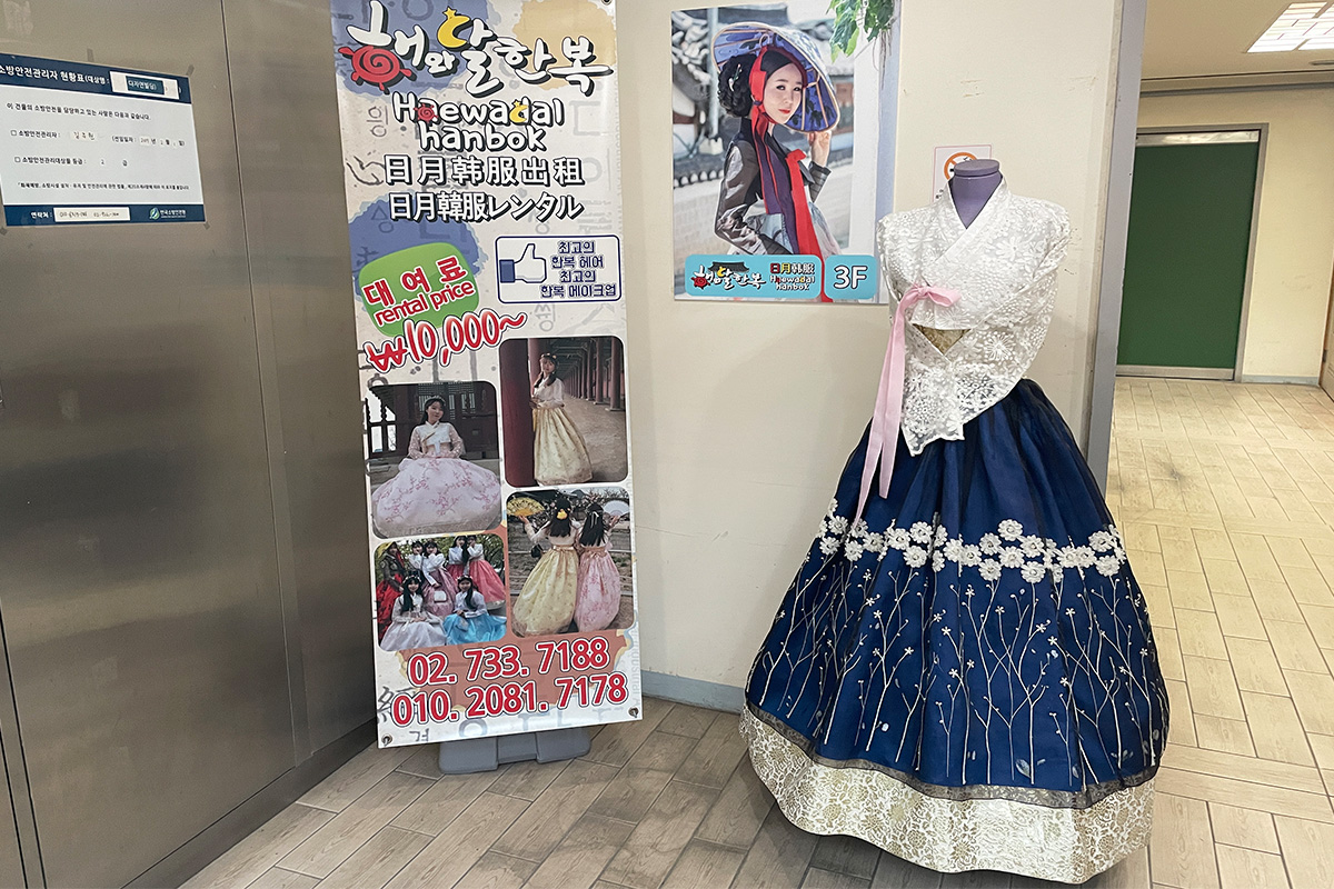在建築內展示租借韓服的廣告和陳列，吸引顧客的視線。