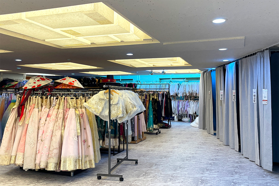 Interior view of a spacious hanbok rental shop filled with dresses and accessories.
