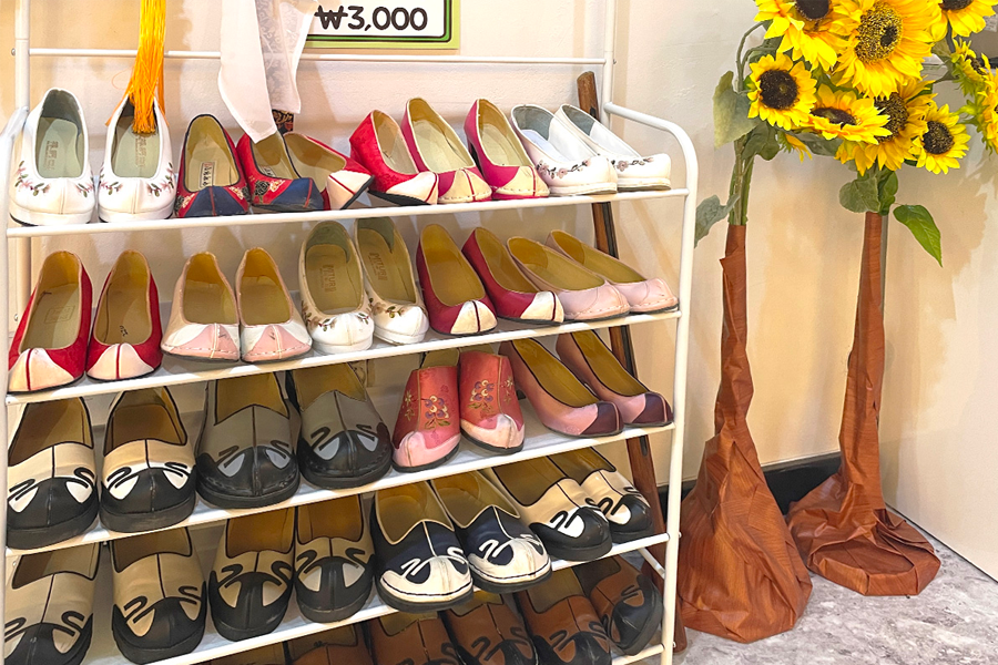 Rack of traditional Korean flat shoes available in a hanbok rental shop.