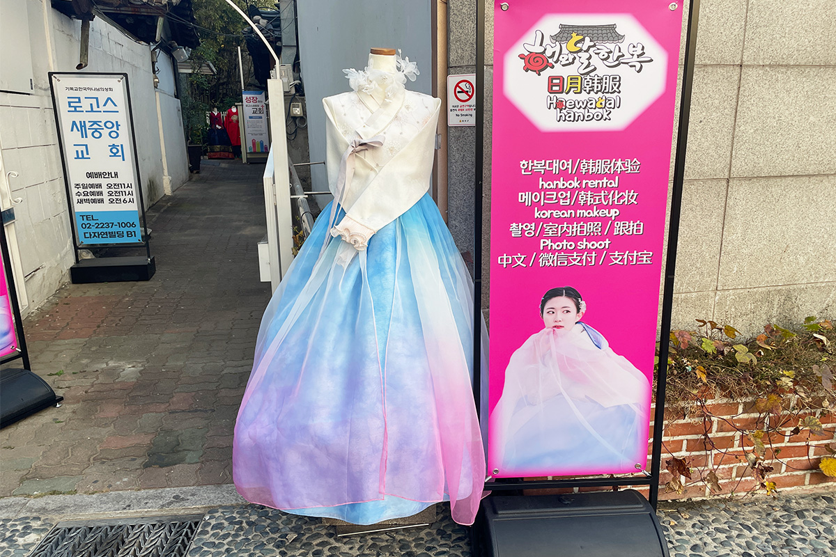 入口位置有明顯的韓服租借廣告牌，展示各式華麗的韓服樣式。