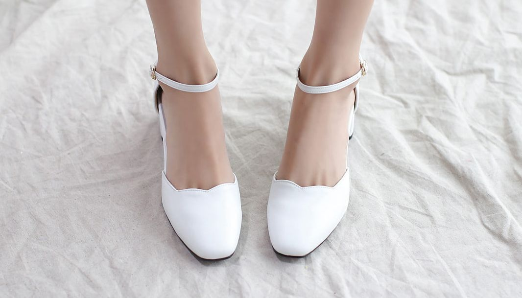 Stylish white scallop-edged high heels from VANILLASHU, highlighting the playful and feminine design embraced by the brand.