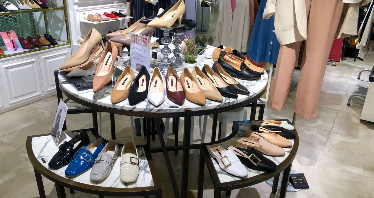 Elegant high heels in various neutral colors on display at a SOVO store, emphasizing the brand's sophisticated and premium image.
