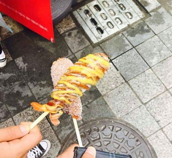 Dual skewered Korean hot dog with enticing coat of mustard and sugar. A unique blend of sweet and savory flavors with cult popularity among locals.