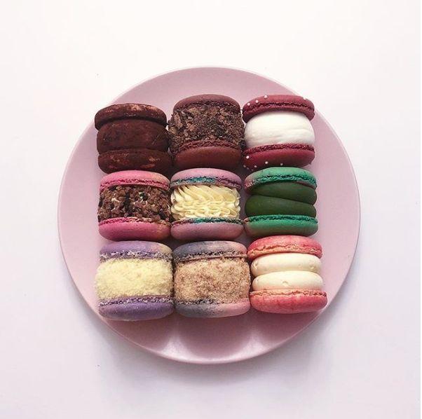 Photo showcasing a platter of vibrant and puffy macarons known as '胖卡龍,' featuring various fillings and toppings, a must-try Korean delight.