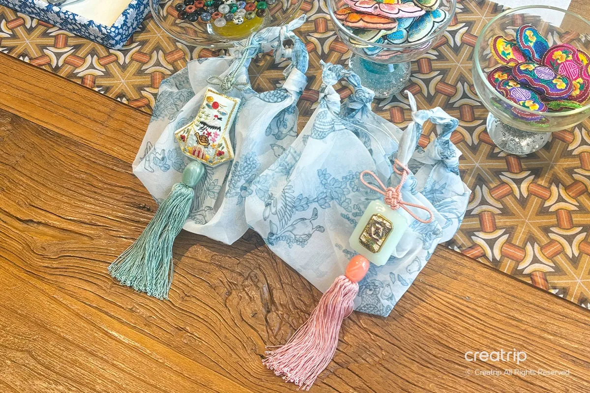 Displayed Korean traditional Hanbok pouch and tassel decorations crafted in DIY workshop, emphasizing elegant handmade gifts.
