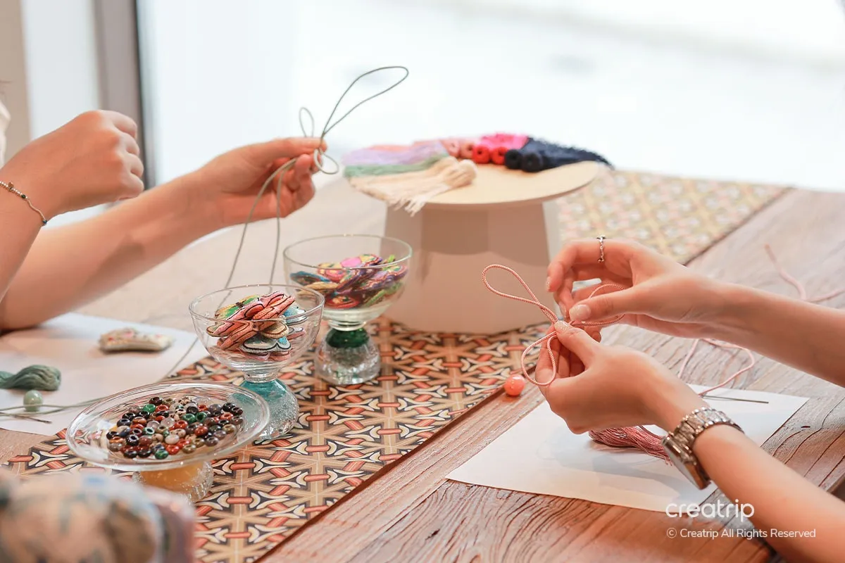 Participants crafting Korean Hanbok-style tassel decorations in DIY workshop, focusing on cultural heritage crafting.