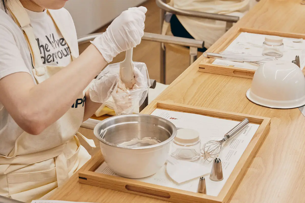 Person participating in Korean DIY skincare workshop, preparing whipped grapefruit face wash in Seoul's DIY class.