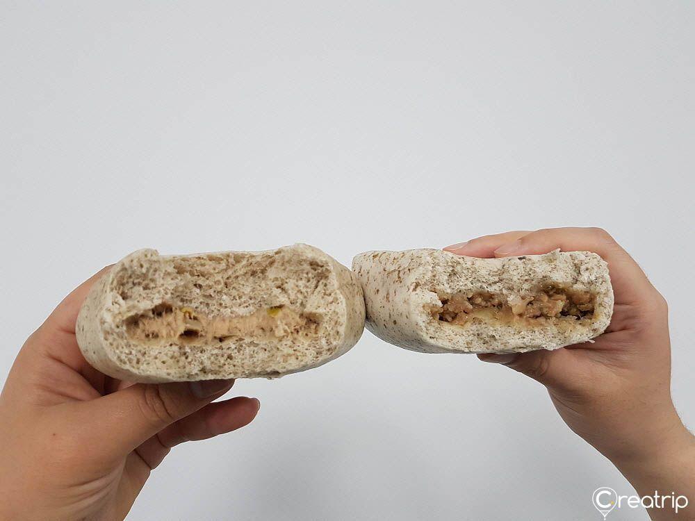 Sliced triangular-shaped bread with visible tuna mayonnaise and bulgogi filling inside