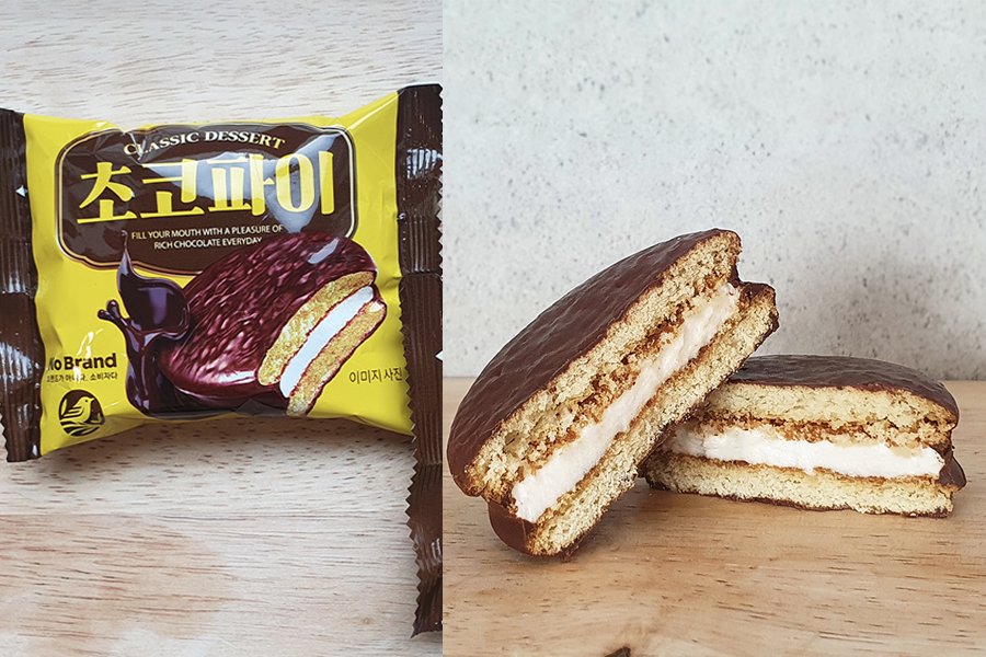 Two halves of a classic No Brand choco pie with marshmallow filling. The image emphasizes the delicious chocolate coating and fluffy interior that's a popular treat choice.