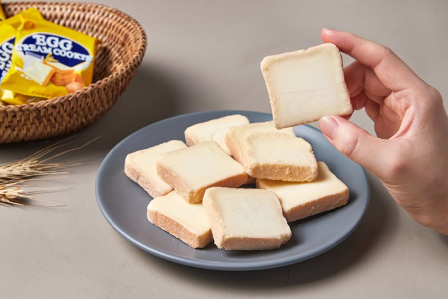 No Brand butter cream cookies neatly arranged on a gray plate, displaying their square shape and creamy filling. Ideal for a light, sweet treat anytime.