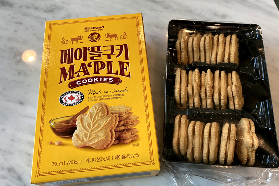 No Brand maple cookies made in Canada, elegantly displayed next to an open box, showcasing the authentic taste and delightful shape ideal for pairing with hot beverages.