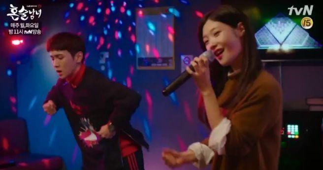 两个人在KTV里跳舞和唱歌，背景是五彩的灯光效果。