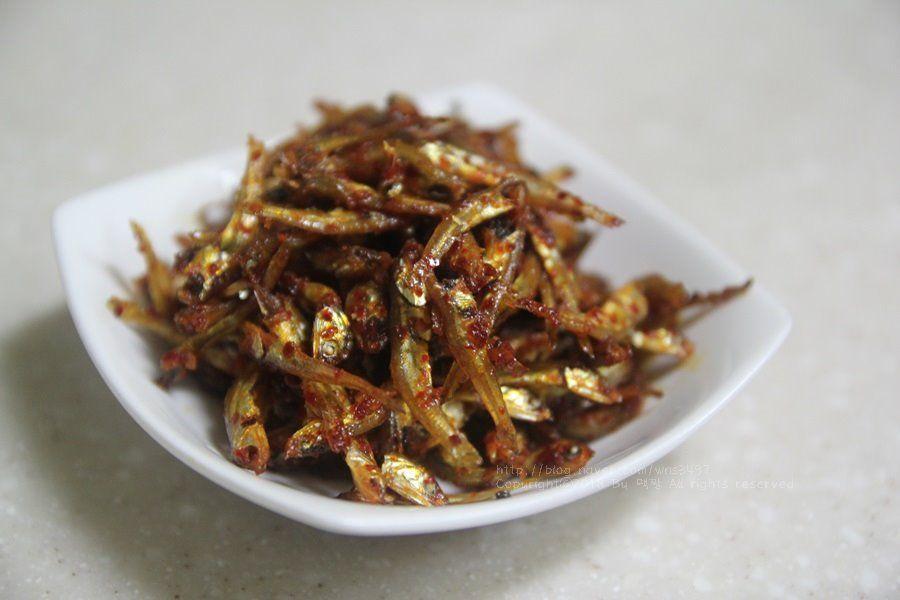 一盘小银鱼干，调味后放在白色小碟中，作为韩国的小菜供应。