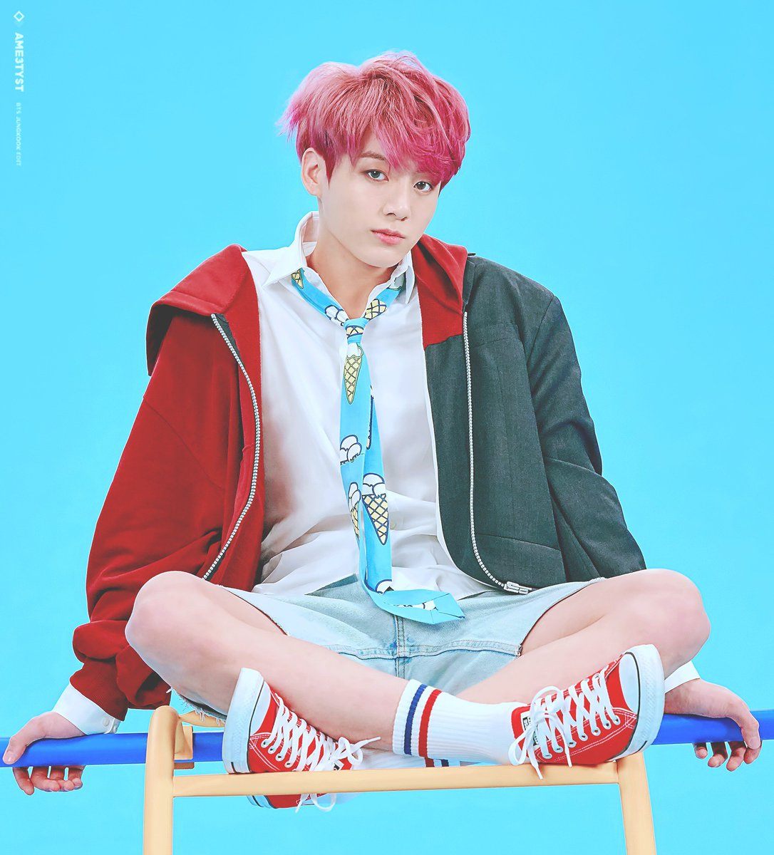 一个穿着红色休闲夹克和短裤的男孩，背景为蓝色幕布。