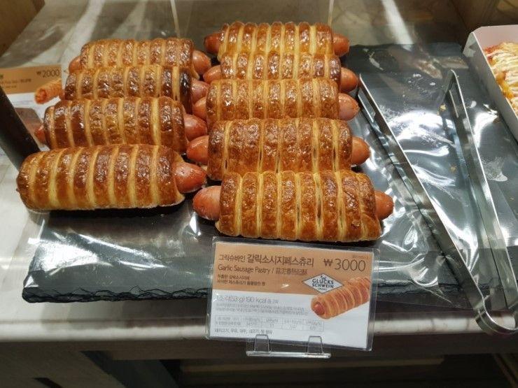 Tray of Garlic Sausage Pastries at Paris Baguette - Freshly baked pastries displayed for customers.