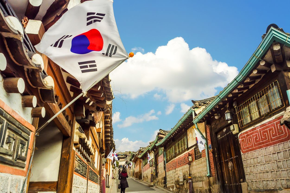 Traditional Korean street in Bukchon Hanok Village featuring the South Korean flag, exemplifying cultural heritage and national pride.