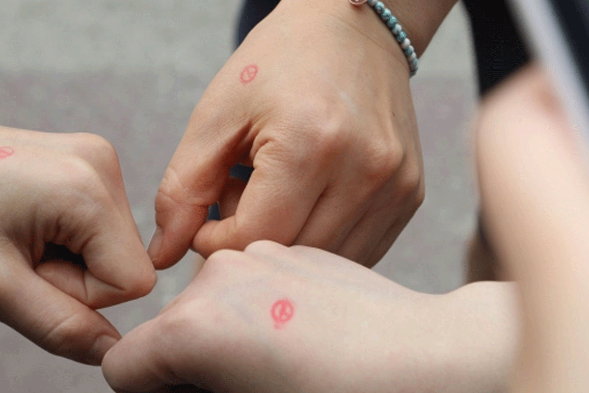 Hands stamped with a voting symbol, indicating participation in South Korea's democratic elections through voter recognition.